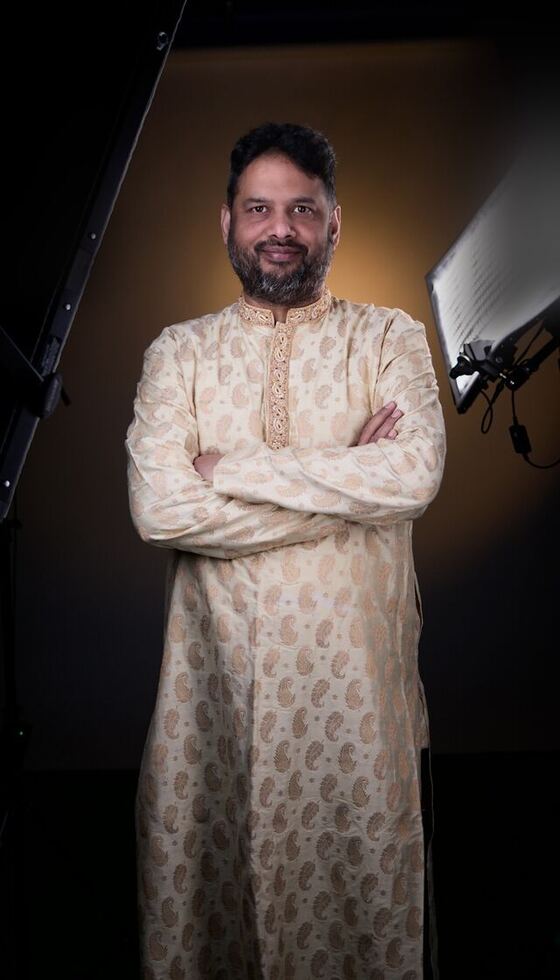 Full length, arms crossed, in a cream kurta